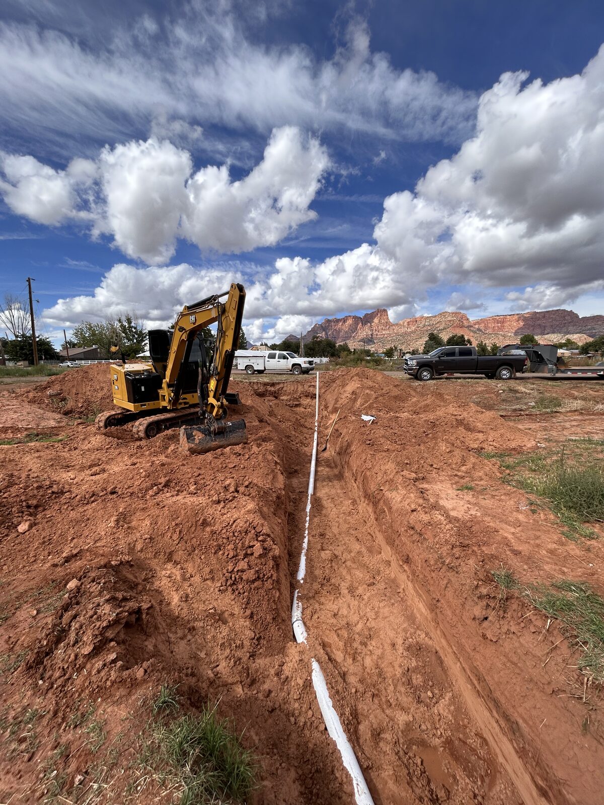 Roxor South mini excavator running a tight utility trench in a Santa Clara, Utah neighborhood